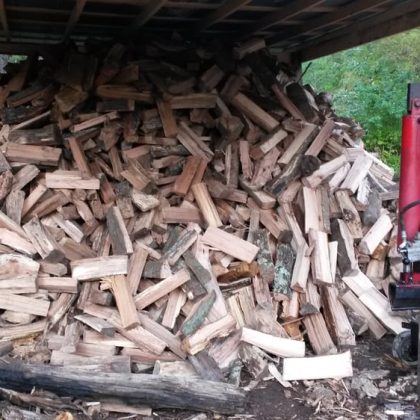 A pile of wooden logs stacked in the back of a truck, ready for transport.